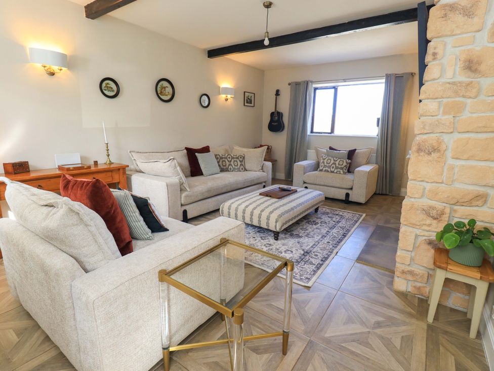 A living room with sofas and a coffee table at Yew Tree Cottage Mealsgate near Ireby