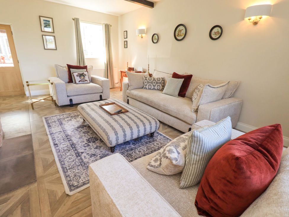 A living room with sofas and a coffee table at Yew Tree Cottage Mealsgate near Ireby