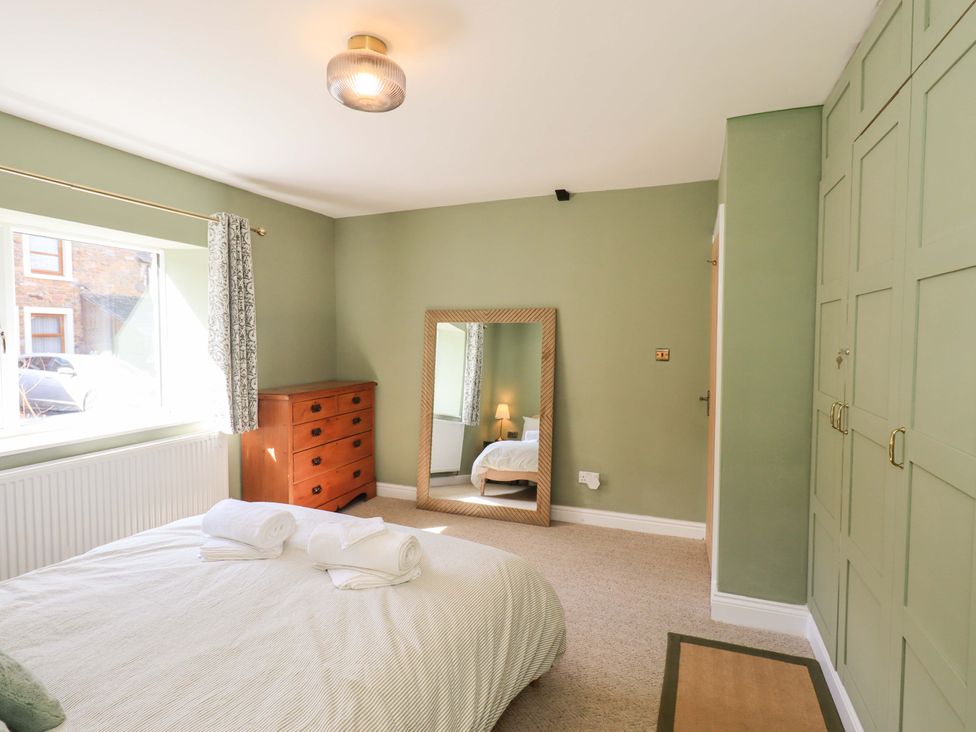 A bedroom with a bed and a dresser at Yew Tree Cottage Mealsgate near Ireby