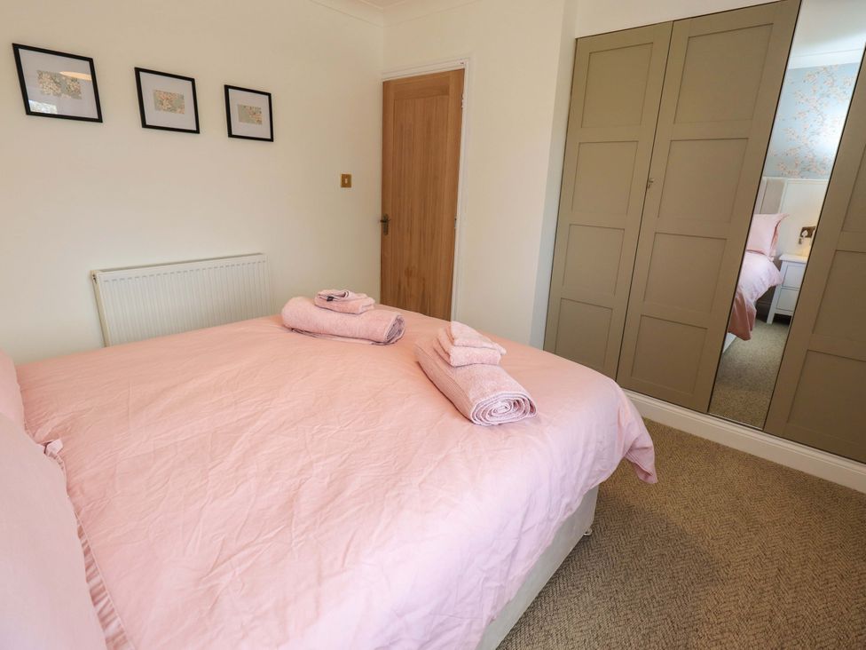 A bedroom with a bed and towels at Yew Tree Cottage Mealsgate near Ireby