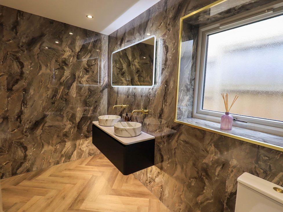 A bathroom with two sinks and a mirror at Yew Tree Cottage Mealsgate near Ireby