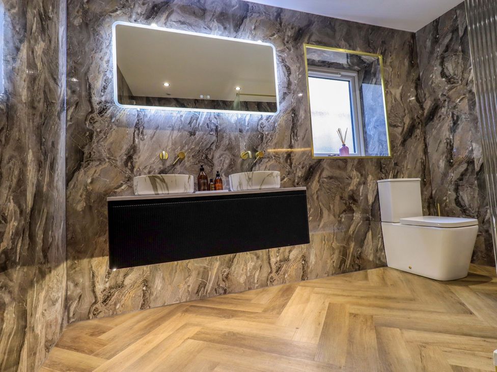 A bathroom with a double sink and toilet at Yew Tree Cottage Mealsgate near Ireby