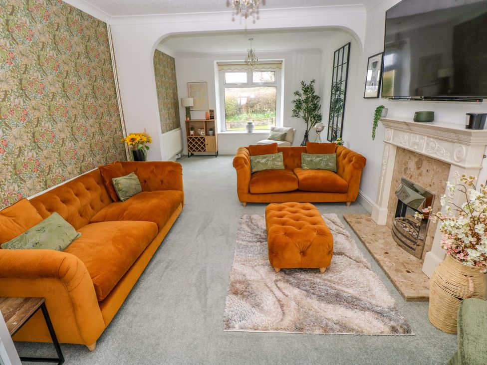 A living room with sofas and a fireplace at Burry House Llanmorlais