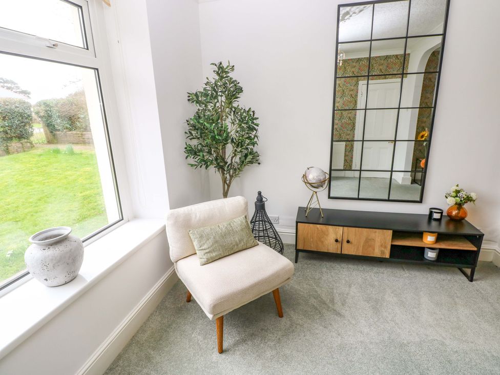 A living room with a plant and armchair at Burry House Llanmorlais