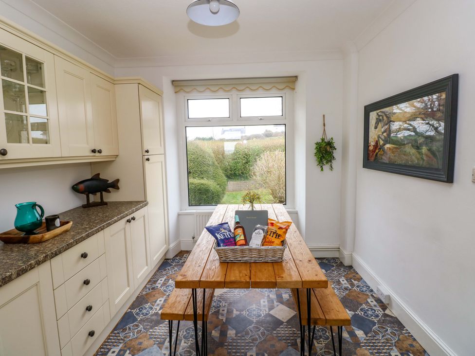 A dining room with a table and snacks at Burry House in Llanmorlais