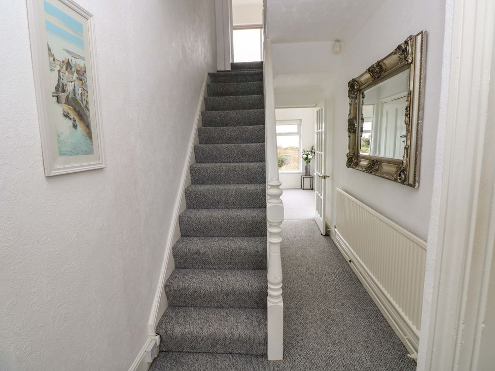 A hallway with a staircase and a painting at Burry House Llanmorlais