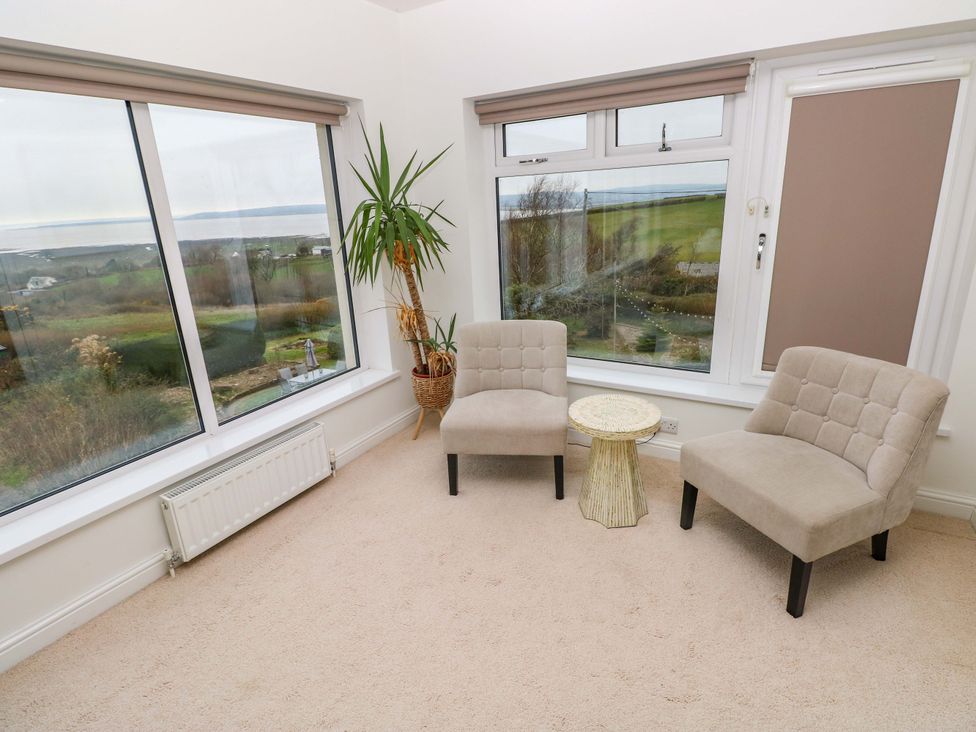 A snug with windows and chairs at Burry House in Llanmorlais