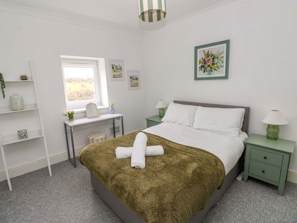 A bedroom with a bed and desk at Burry House in Llanmorlais