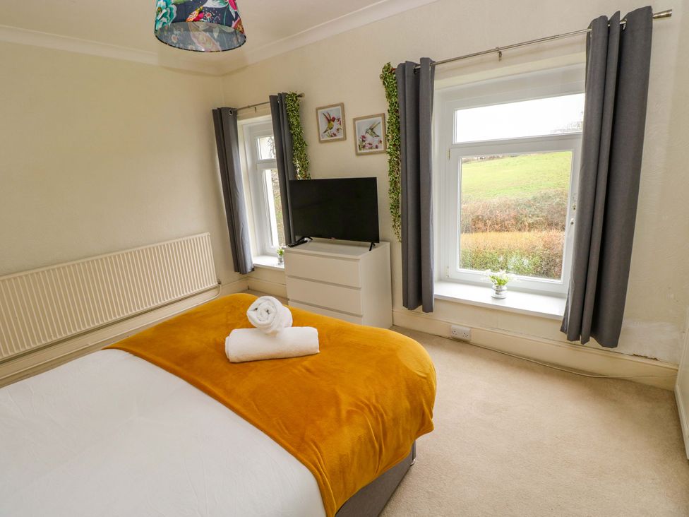 A bedroom with a bed and television at Burry House Llanmorlais