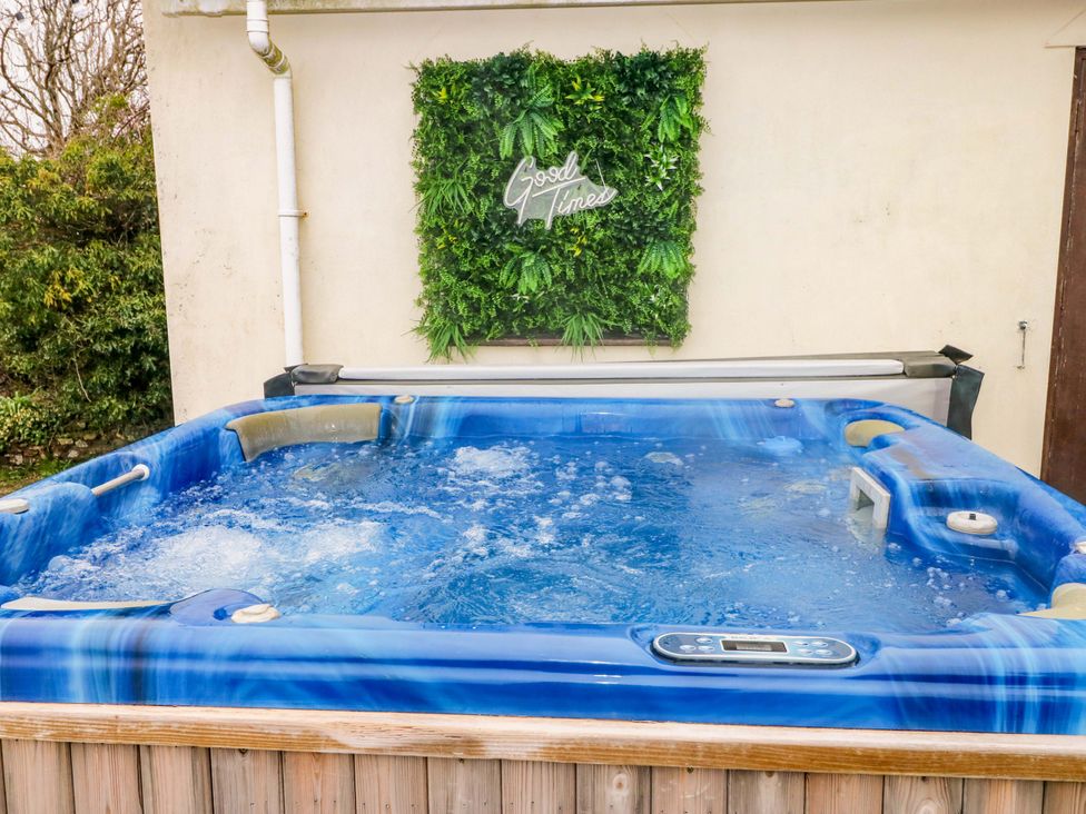 A hot tub with water and greenery background at Burry House in Llanmorlais