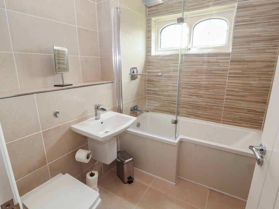 A bathroom with a bathtub, sink, and toilet at 3 Hawk Place in Moresby Parks near Whitehaven