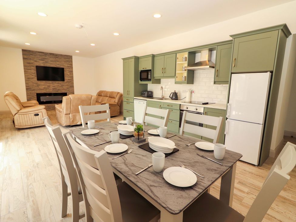 A kitchen and dining area with table and chairs at Teach Ti in Miltown Malbay