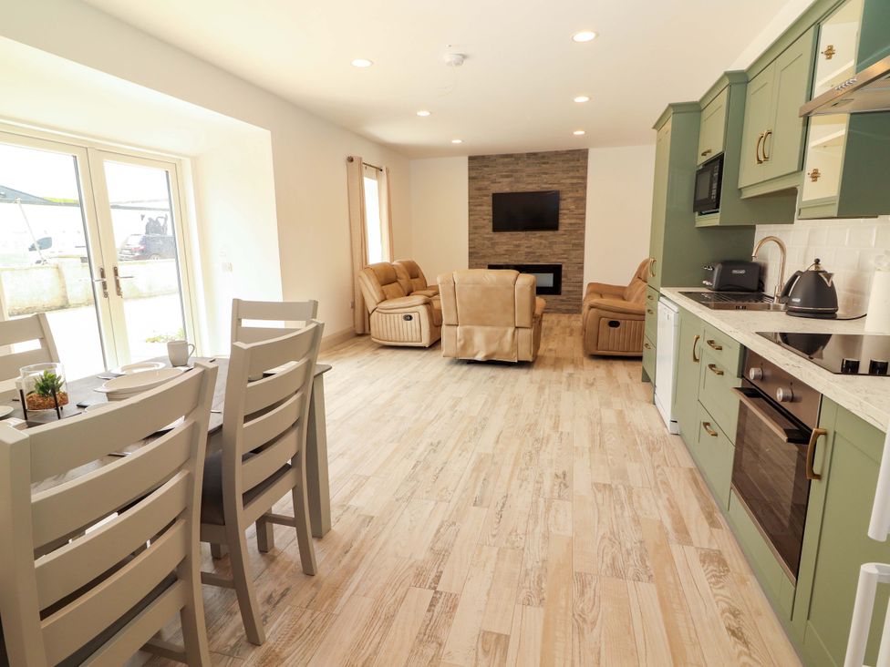 A living room with a dining table and chairs at Teach Ti in Miltown Malbay
