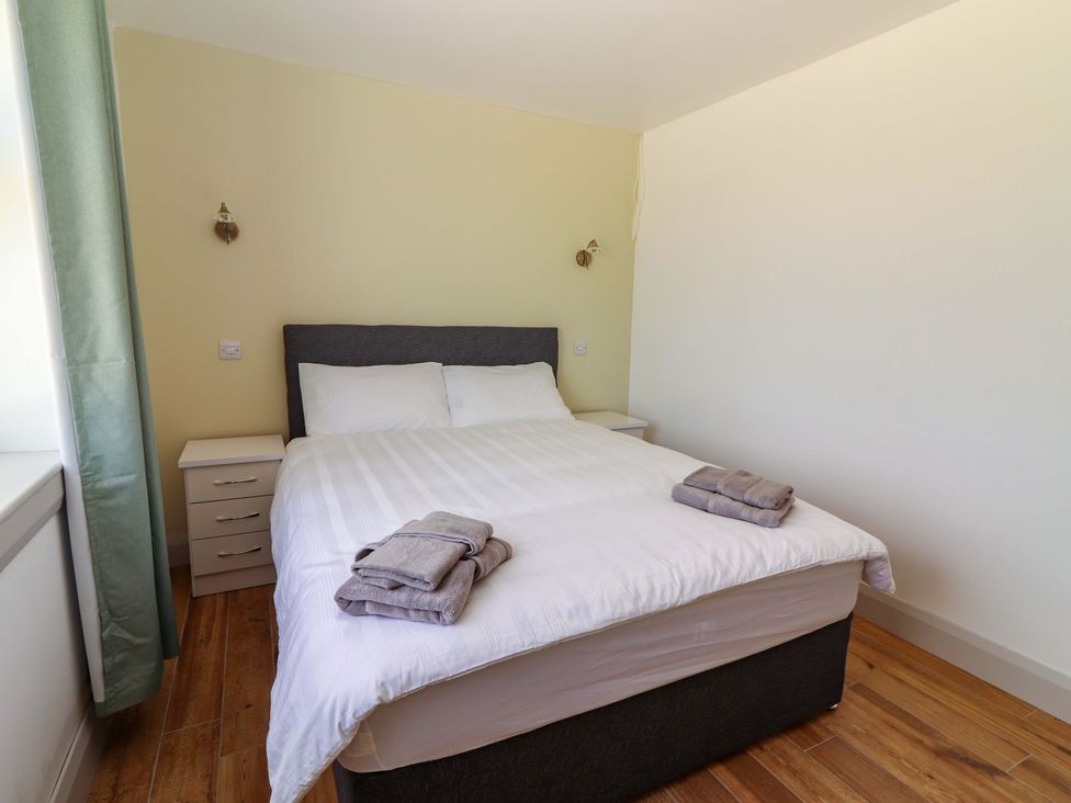 A bedroom with a bed and bedside table at Teach Ti in Miltown Malbay