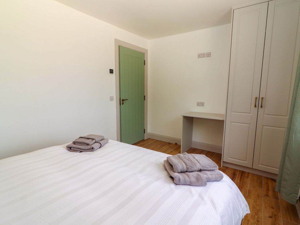 A bedroom with a bed and towels at Teach Ti in Miltown Malbay