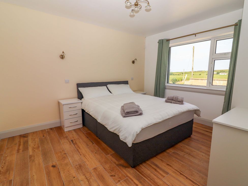 A bedroom with a bed and nightstand at Teach Ti in Miltown Malbay