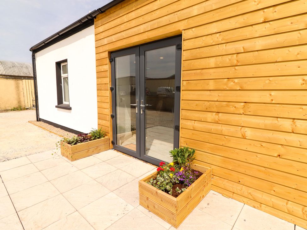 An outdoor area with double doors and flower planters at Teach Ti in Miltown Malbay