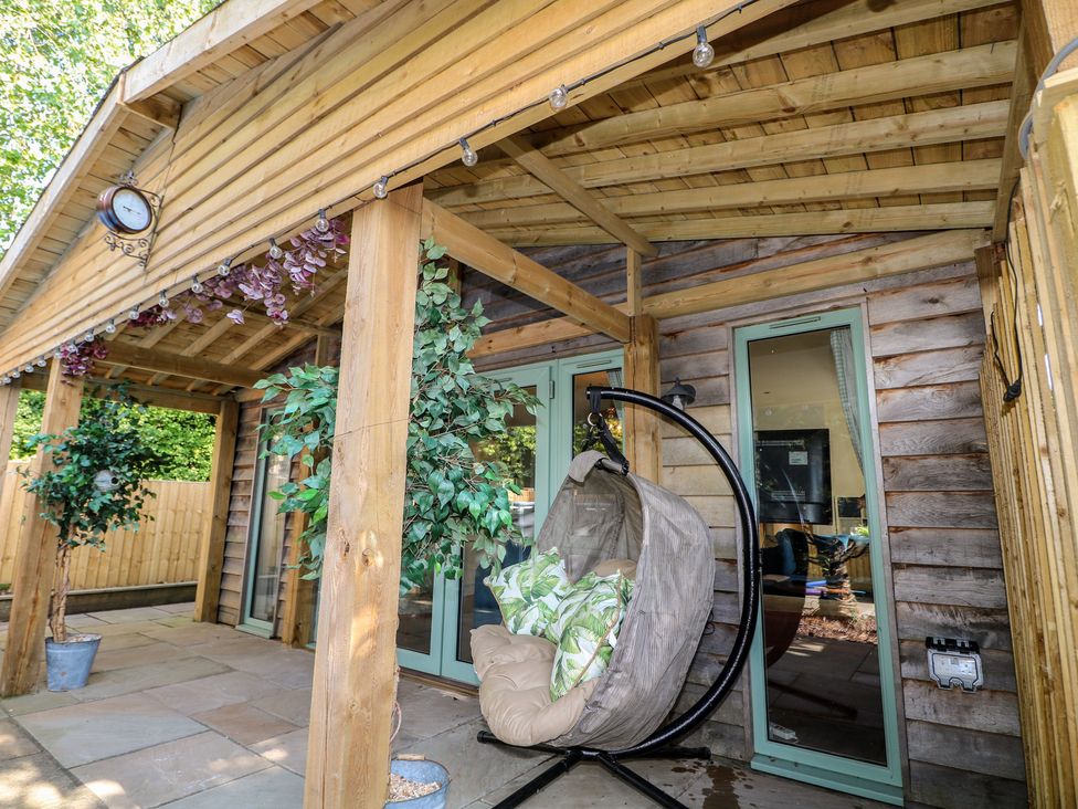 An outdoor area with a hanging chair and plants at El -Nido, Alton