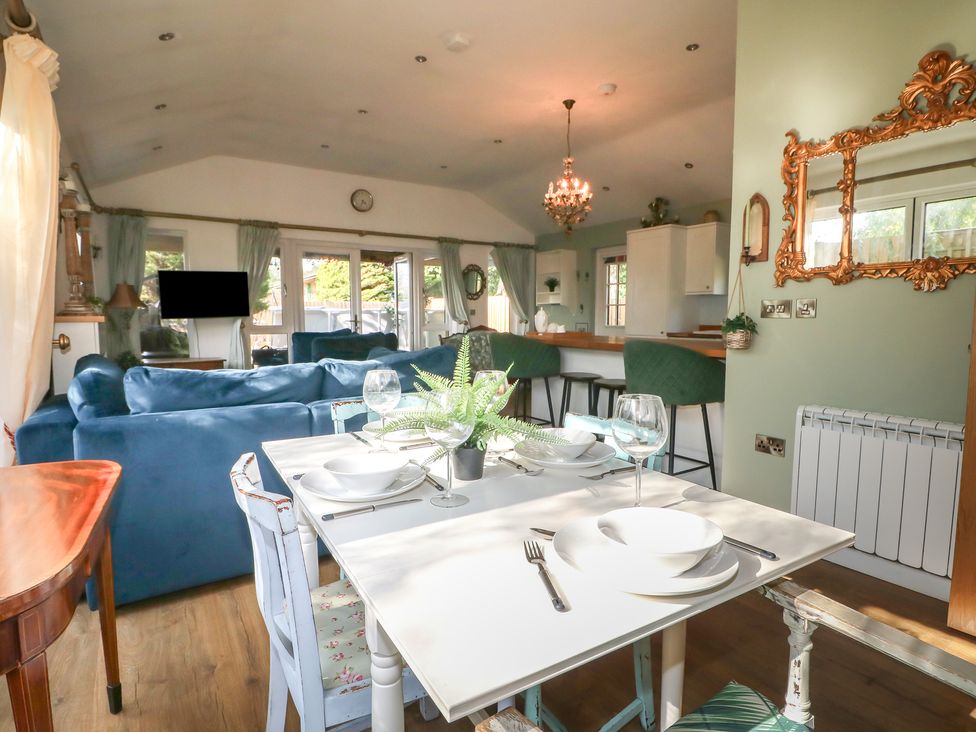 A dining area with a table and sofa at El -Nido in Alton