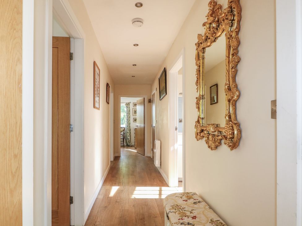 A hallway with a mirror and bench at El -Nido in Alton