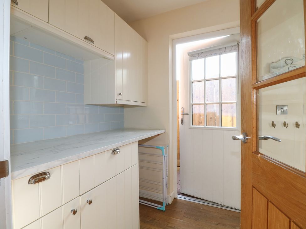 A kitchen with cabinets and door at El -Nido in Alton
