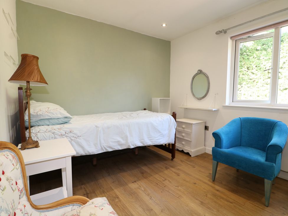 A bedroom with a bed, lamp, chair and mirror at El -Nido in Alton