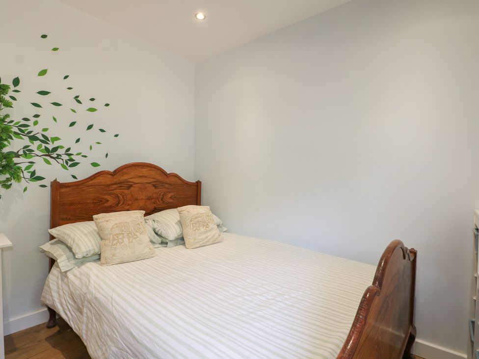 A bedroom with a bed and leaves on the wall at El -Nido in Alton