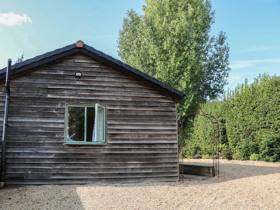 A wooden building with a window and gravel area at El -Nido in Alton