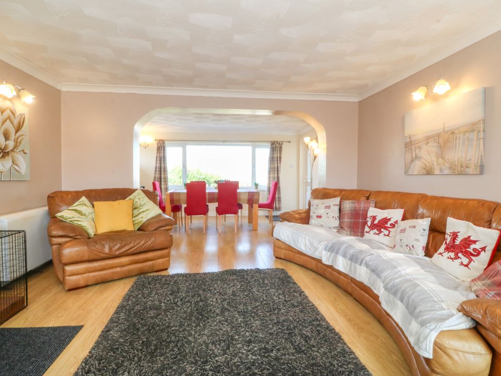 A living room with leather sofas and a dining area at Llain Delyn Capel Mawr near Malltraeth