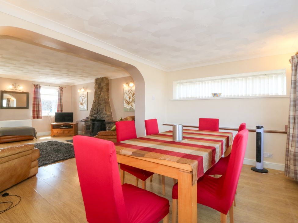 A dining room with a table and chairs at Llain Delyn in Capel Mawr near Malltraeth
