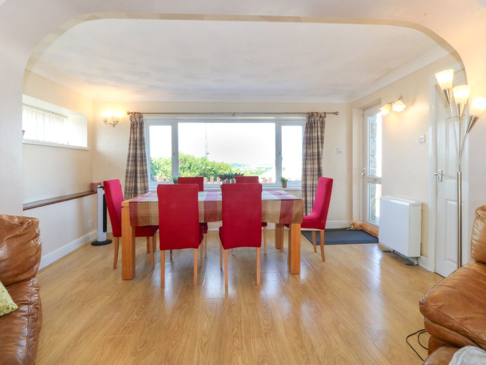 A dining room with a table and chairs at Llain Delyn in Capel Mawr near Malltraeth
