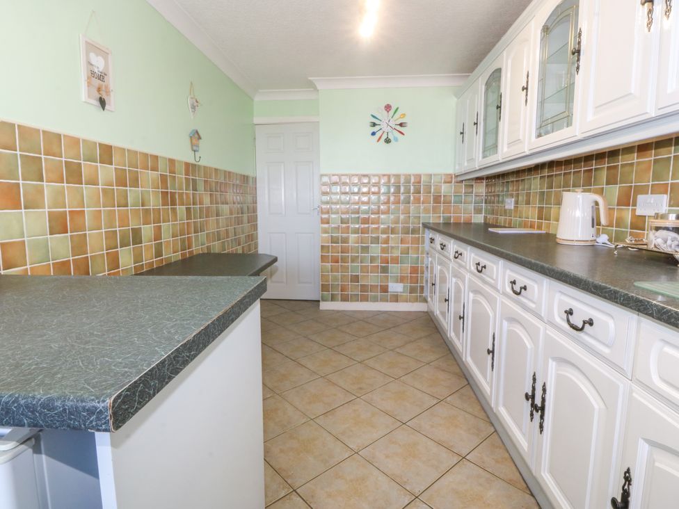 A kitchen with a worktop and cupboards at Llain Delyn Capel Mawr near Malltraeth