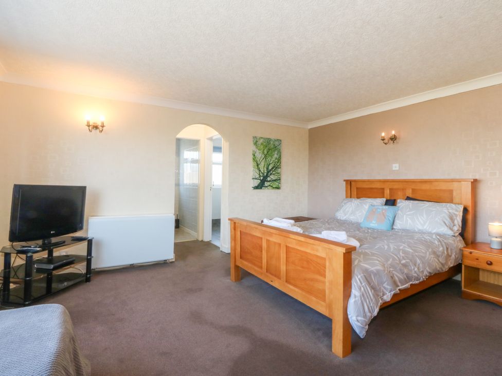 A bedroom with a bed and tv at Llain Delyn in Capel Mawr near Malltraeth