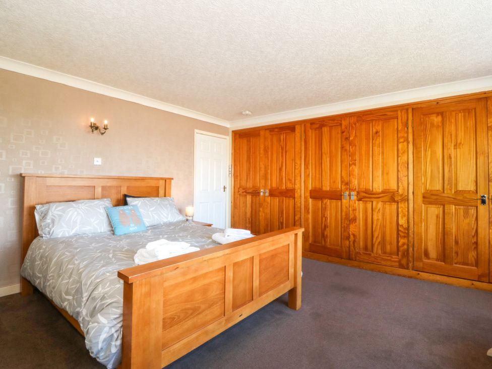A bedroom with a bed and a closet at Llain Delyn near Capel Mawr Malltraeth
