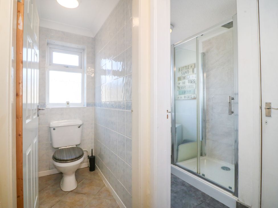 A bathroom featuring a toilet and a shower at Llain Delyn Capel Mawr near Malltraeth