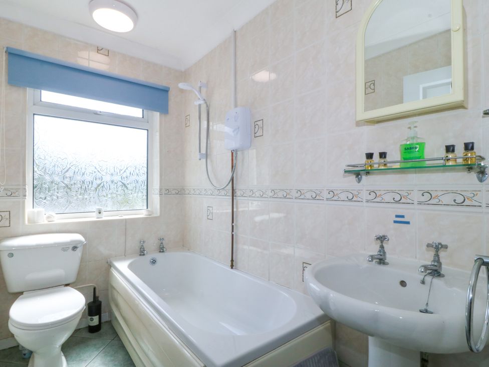 A bathroom with a bathtub, toilet, and sink at Llain Delyn Capel Mawr near Malltraeth