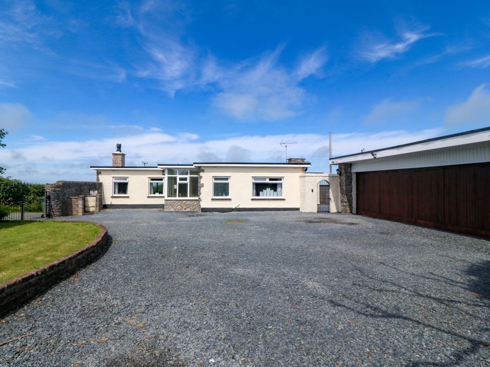 A house with a garage and gravel driveway at Llain Delyn Capel Mawr near Malltraeth