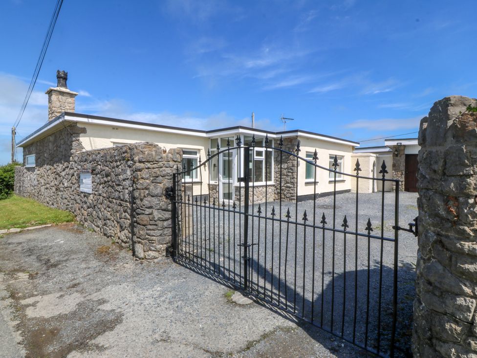 A house with stone walls and a gate at Llain Delyn in Capel Mawr near Malltraeth