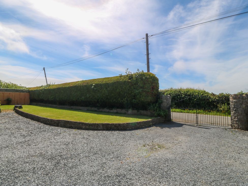 An outdoor area with a hedge and gravel driveway at Llain Delyn Capel Mawr near Malltraeth