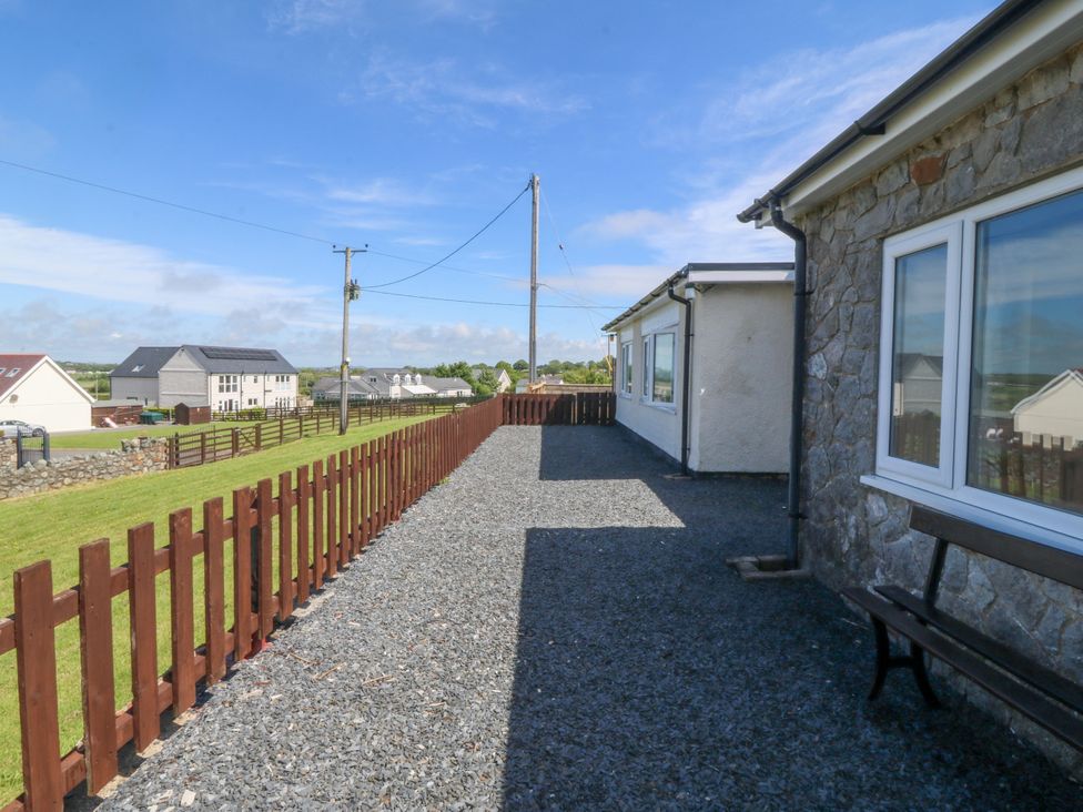 An outdoor area with gravel path and fence at Llain Delyn Capel Mawr near Malltraeth