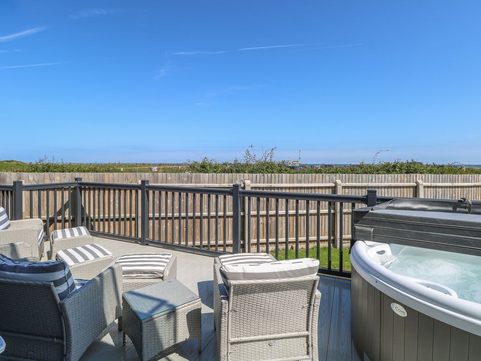An outdoor space with chairs and hot tub at Life's a Beach in Bacton