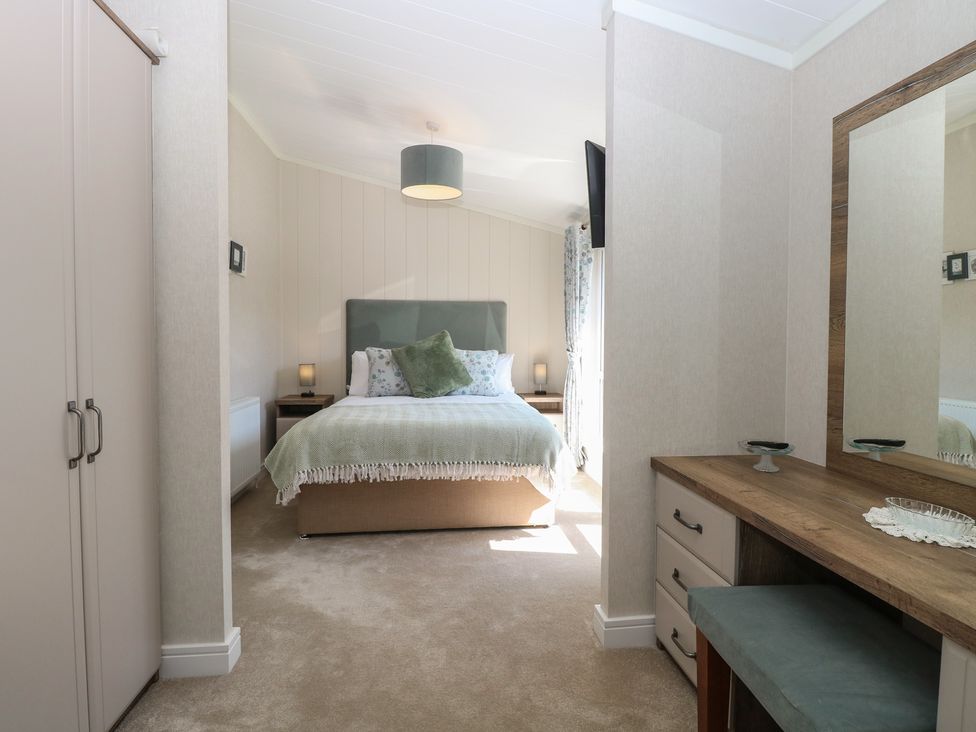 A bedroom with a bed and dresser at Life's a Beach in Bacton