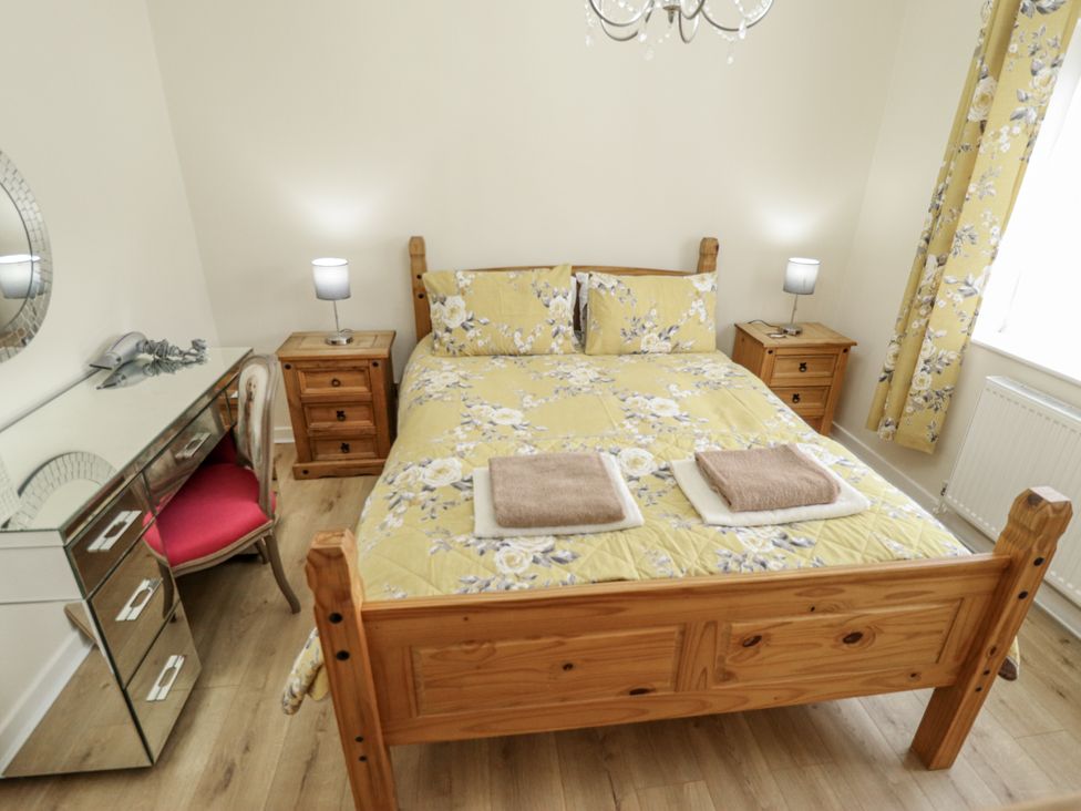 A bedroom with a bed and nightstands at 5 Links Court in Skegness