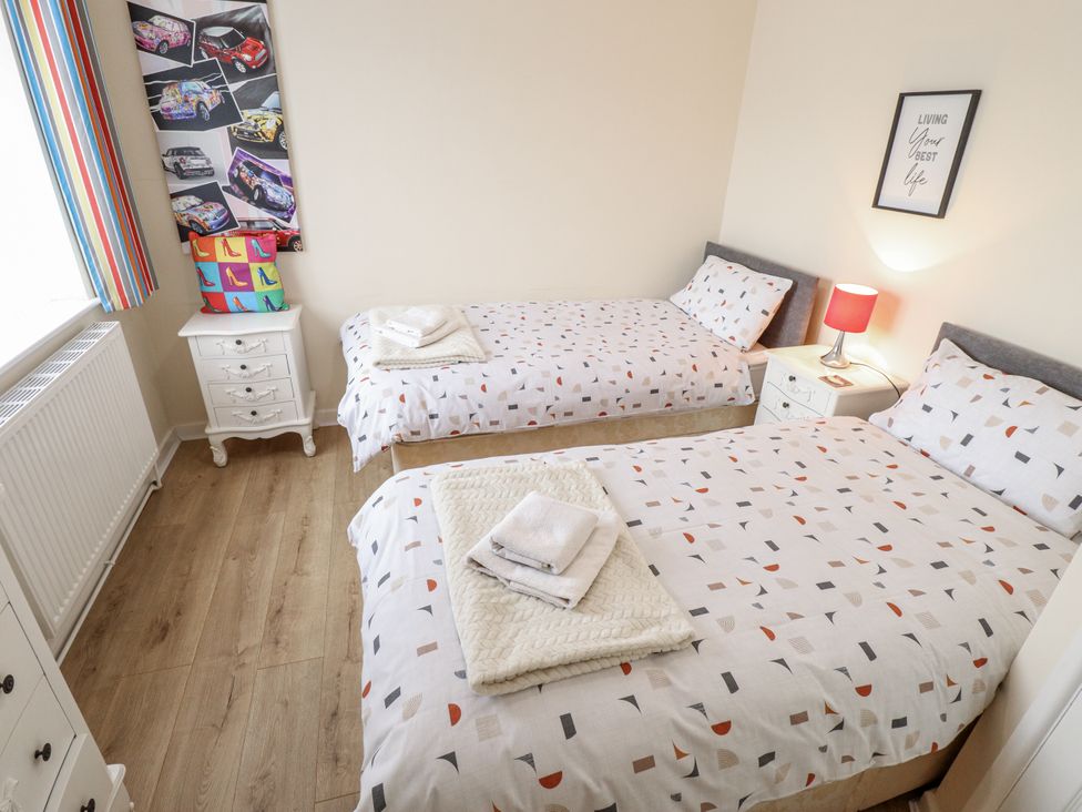 A bedroom with two beds and a nightstand at 5 Links Court in Skegness