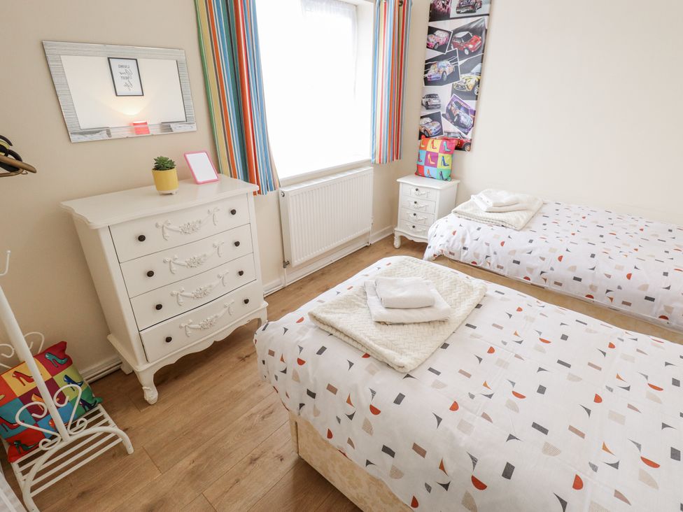 A bedroom with two beds and a dresser at 5 Links Court in Skegness