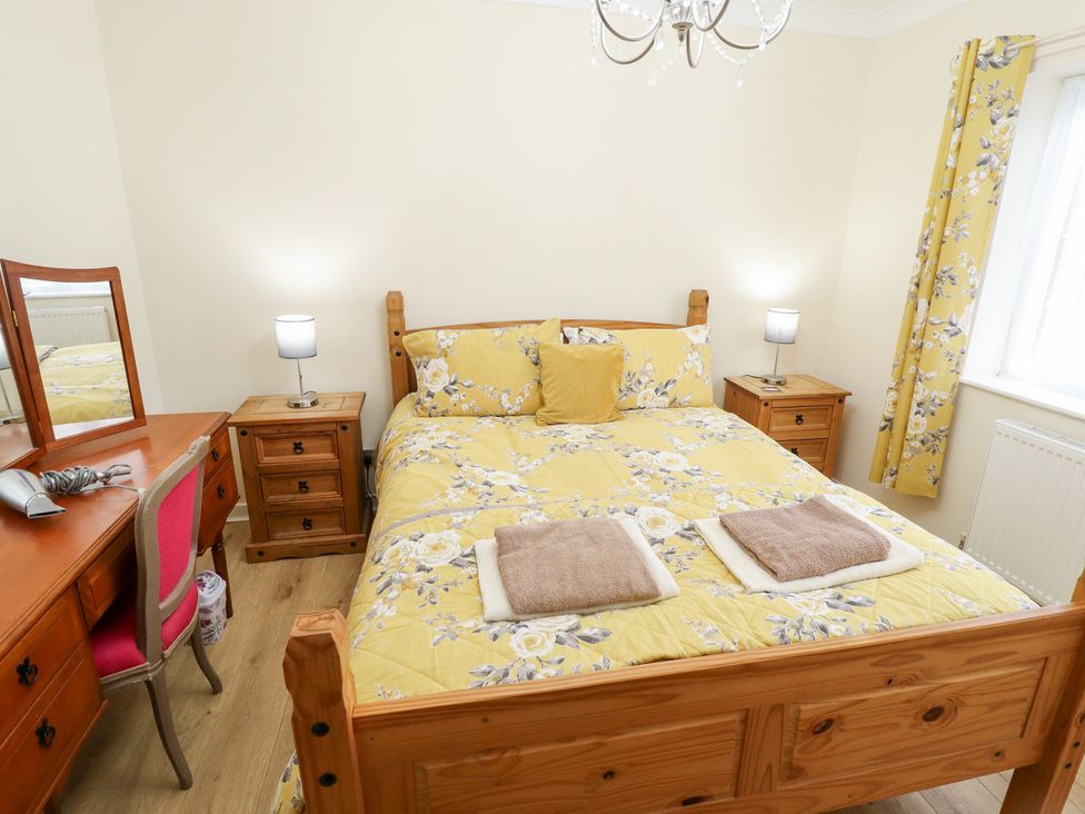 A bedroom with a bed and dressing table at 5 Links Court in Skegness