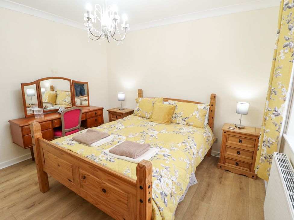 A bedroom with a bed and desk at 5 Links Court in Skegness