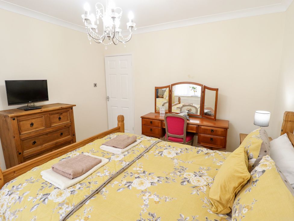 A bedroom with a bed, television, and dresser at 5 Links Court in Skegness