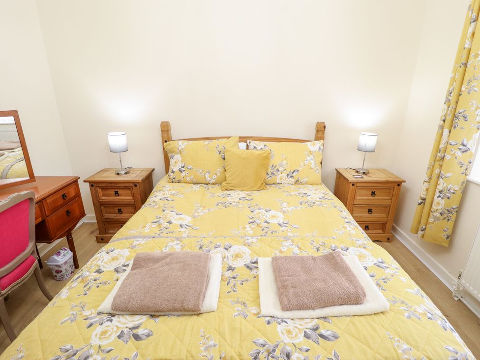 A bedroom with a double bed and nightstands at 5 Links Court in Skegness