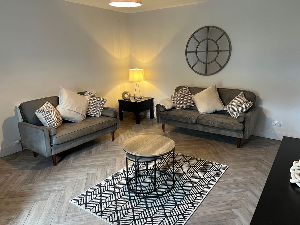 A living room with two sofas and a coffee table at 1 Links Place in Nairn